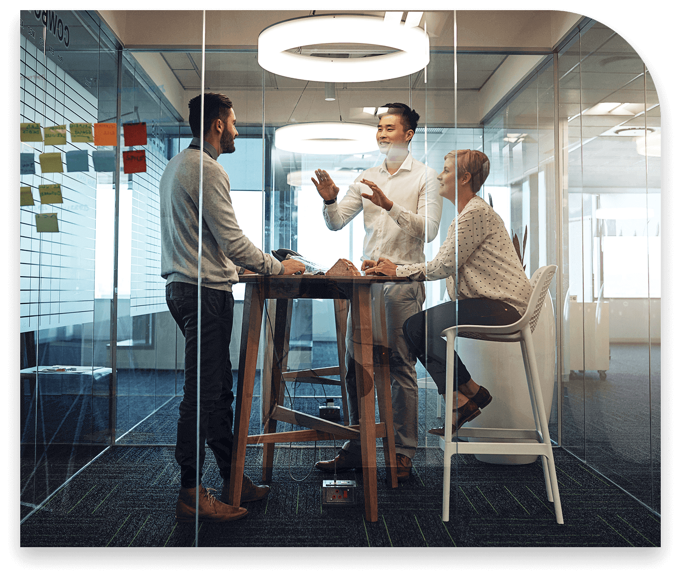 Three Syneos Health employees collaborating in a meeting room, discussing inclusive efforts within Employee Resource Groups.